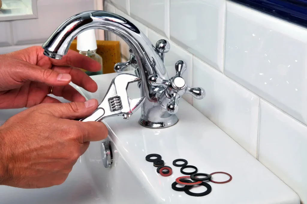 Plumber performing maintenance on a bathroom faucet in Peachtree City