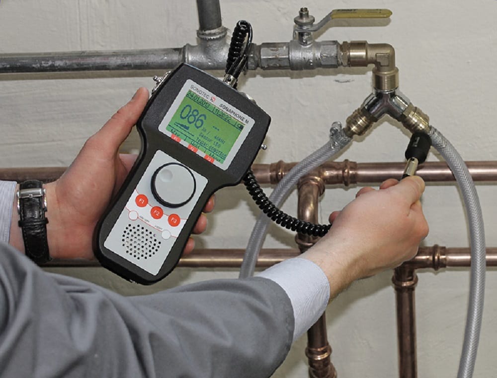 Plumber testing pipes with electronic leak detection equipment in Peachtree City