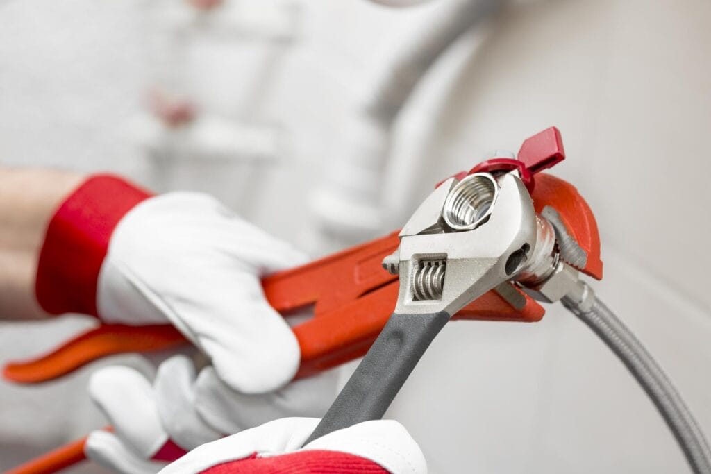 Plumber holding pipe wrenches for an emergency repair in Peachtree City