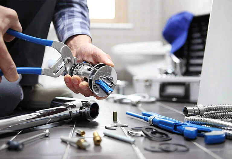 Technician repairing a plumbing fixture with professional tools in Peachtree City
