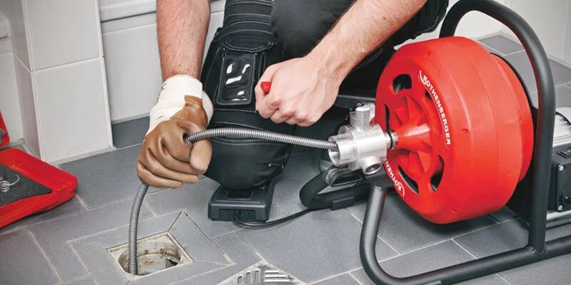 Plumber using a drain-cleaning machine in Peachtree City
