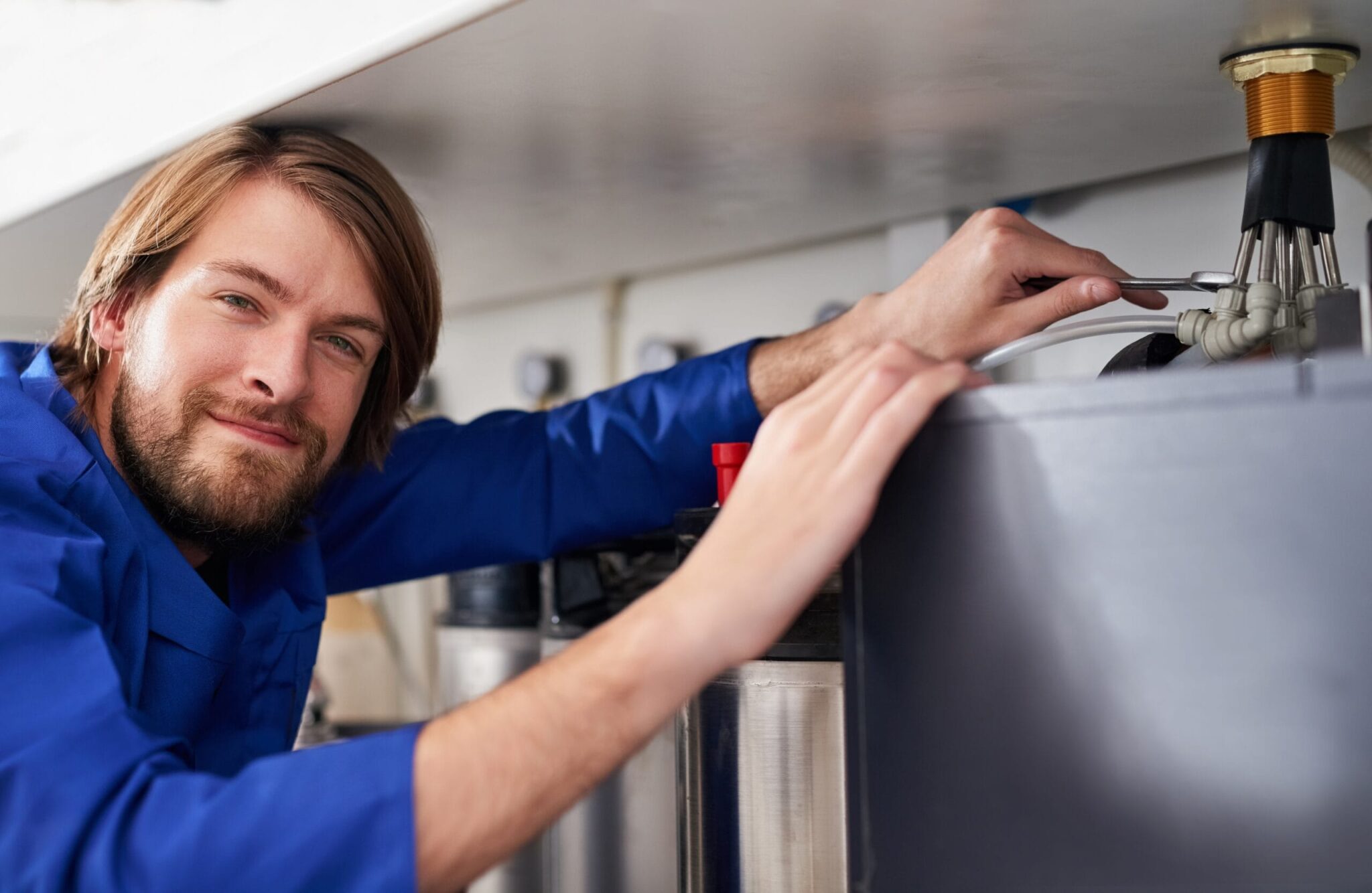 Technician servicing a residential water heater tank in Peachtree City