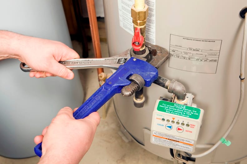 Plumber repairing a water heater valve in Peachtree City